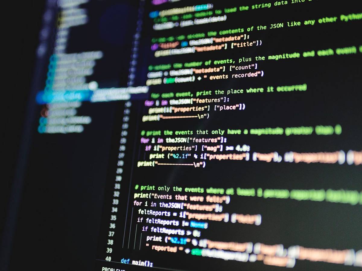 Close-up of colorful program code in a text editor on a dark monitor.